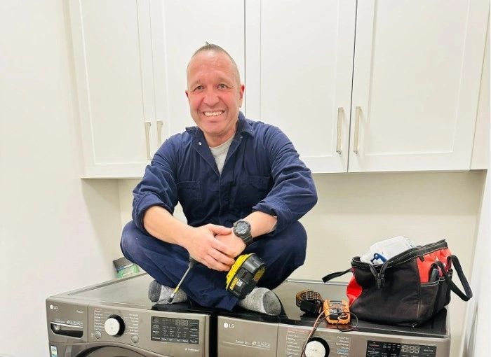 ApplianceKom technician performing appliance repair in a kitchen